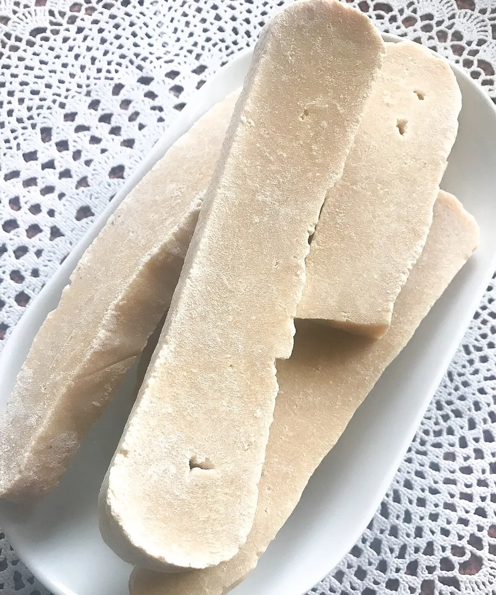 Slabs of dried aaruul curd on a plate, pale and hard
