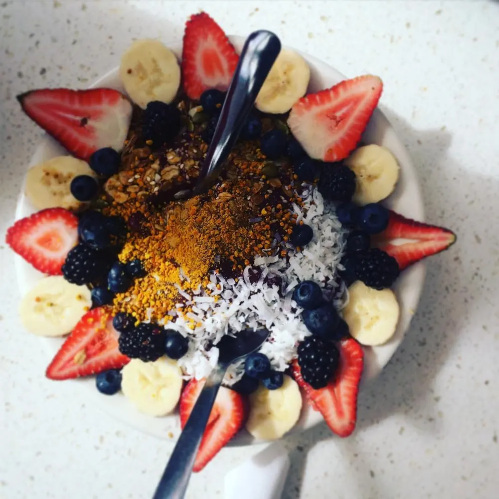 An açaí bowl topped with banana, berries, granola and coconut