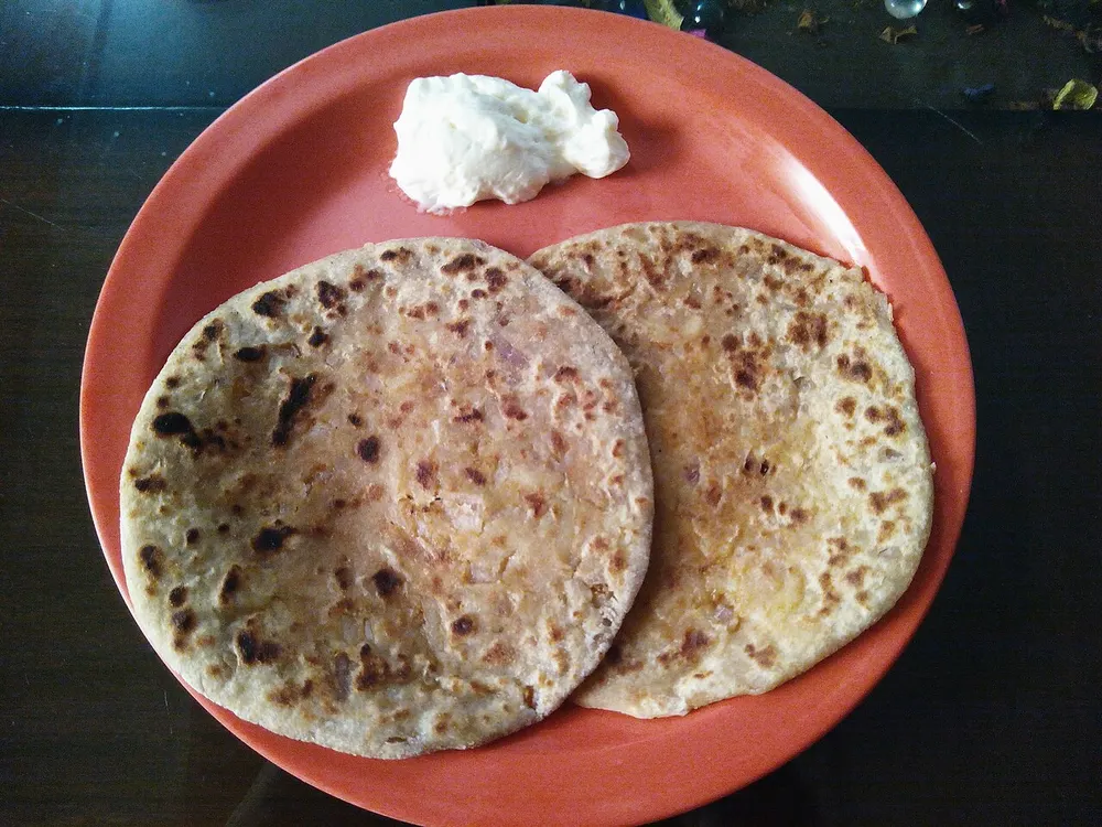 Aloo paratha — potato-stuffed griddle flatbread, served with butter