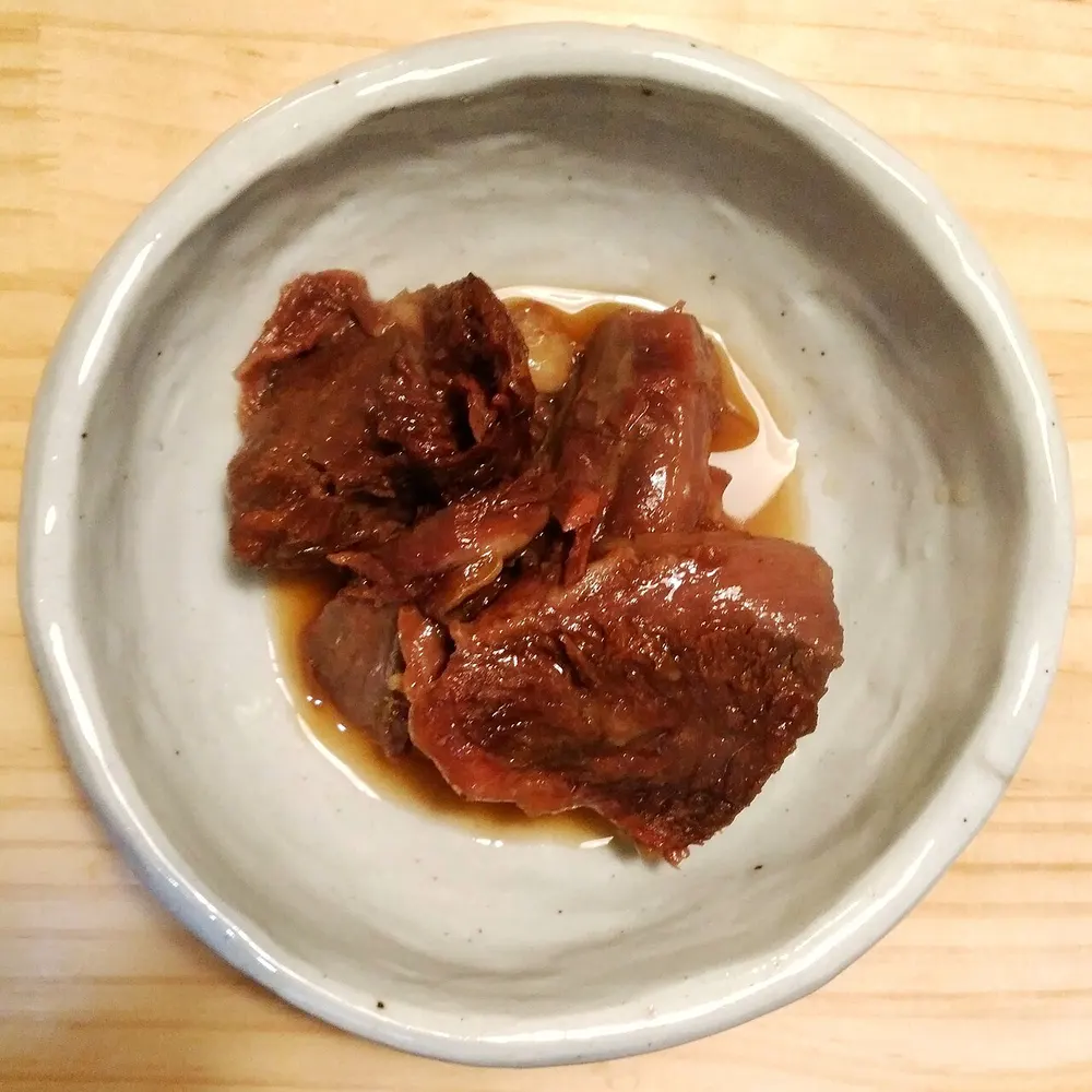 A small ceramic bowl of jangjorim — chunks of soy-braised beef glossy with their braising sauce