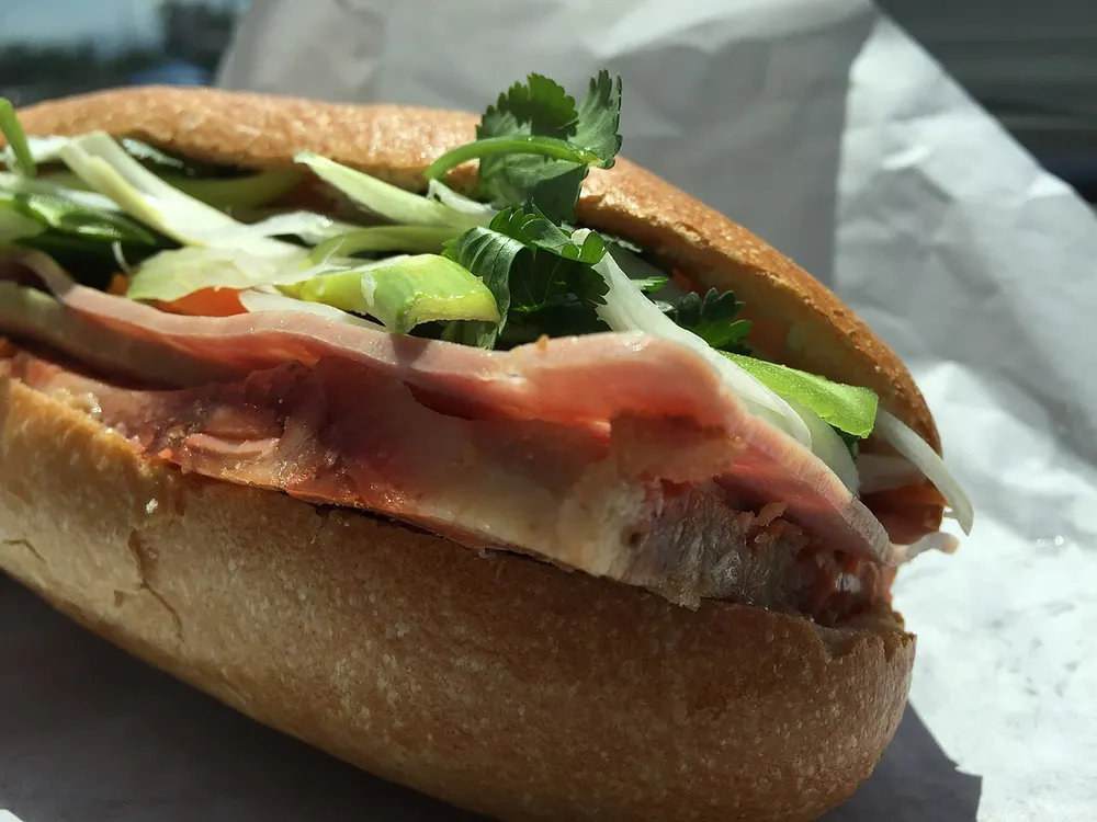 A crackly baguette filled with cold cuts, pickled carrot, cucumber and cilantro