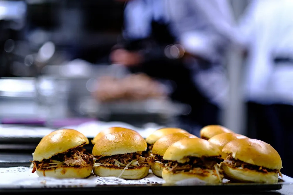 A tray of soft buns filled with shredded pork and slaw