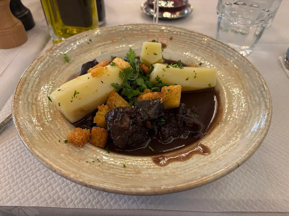 Beef and mushrooms in a dark glossy red-wine sauce, served with boiled potatoes and parsley