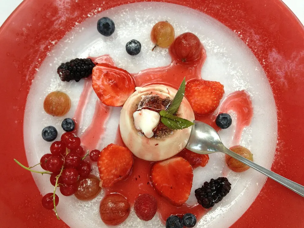 Panna cotta — set cream dessert with a berry coulis and fresh berries