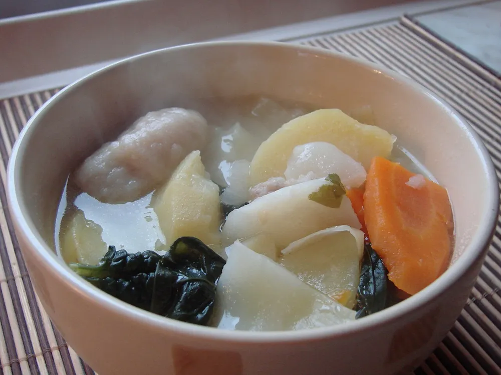 A bowl of boil-up — broth with a doughboy, potato, kūmara, carrot and dark greens