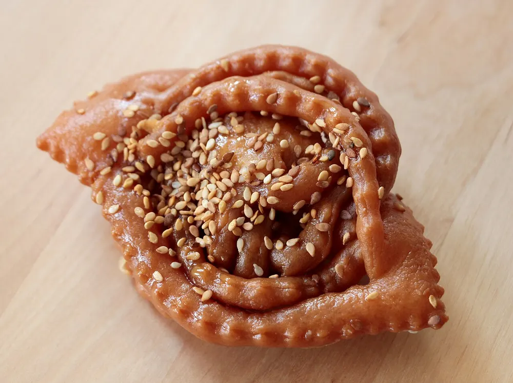 A flower-shaped sesame pastry glazed with honey