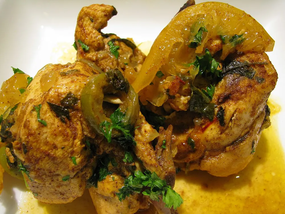 Braised chicken with preserved lemon slices, green olives and cilantro in a saffron-yellow sauce