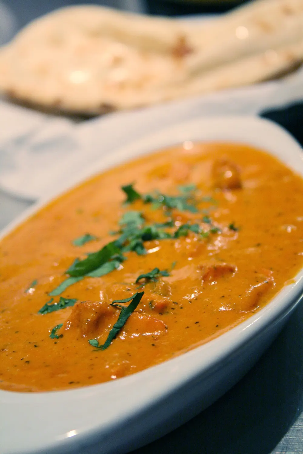Chicken tikka masala — grilled chicken in a creamy spiced tomato sauce, with naan