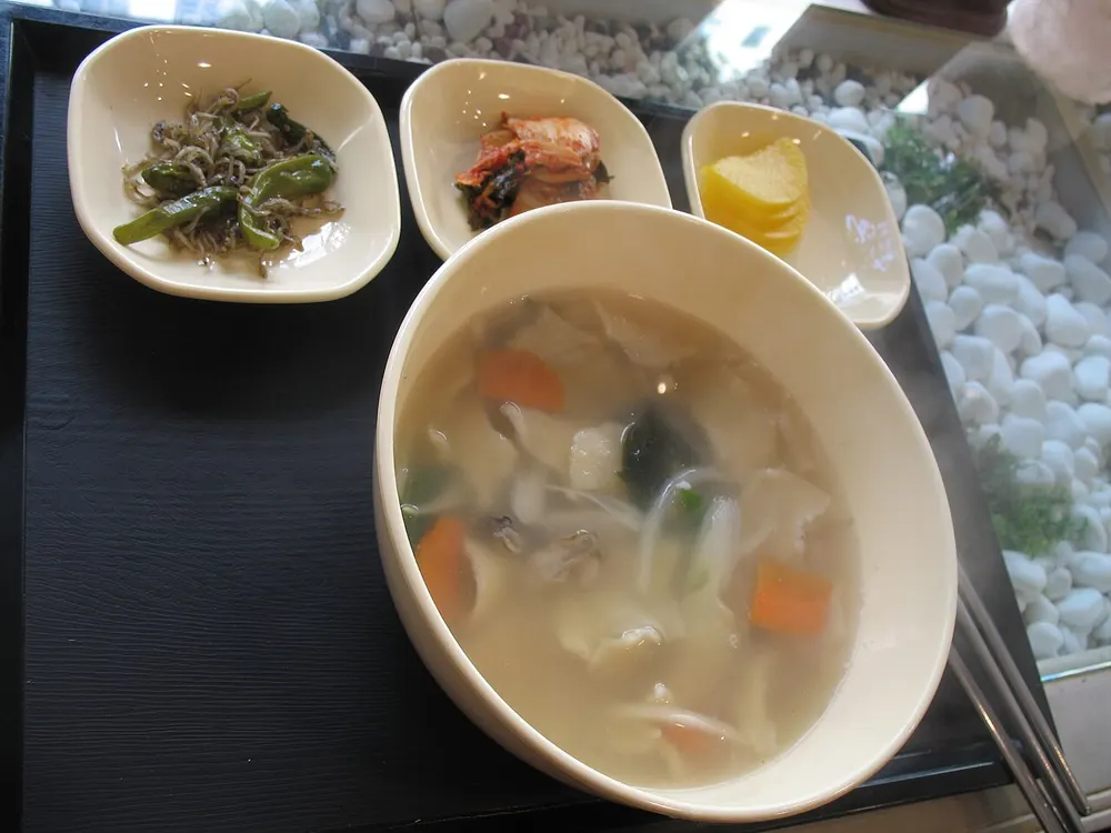 Sujebi — hand-torn dough flakes in a clear vegetable broth