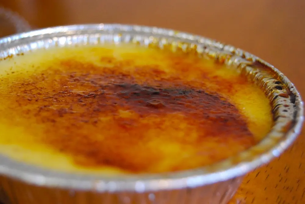 The amber sugar crust of a crème brûlée, burnt hard across the whole surface