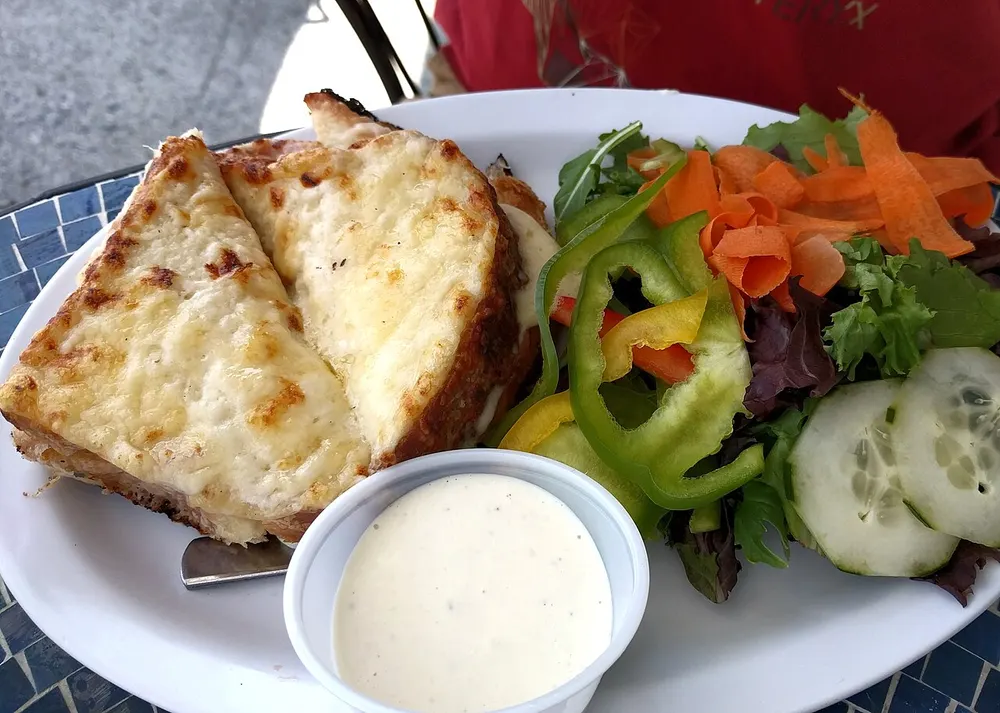 A croque-monsieur browned under the grill, served with a green salad