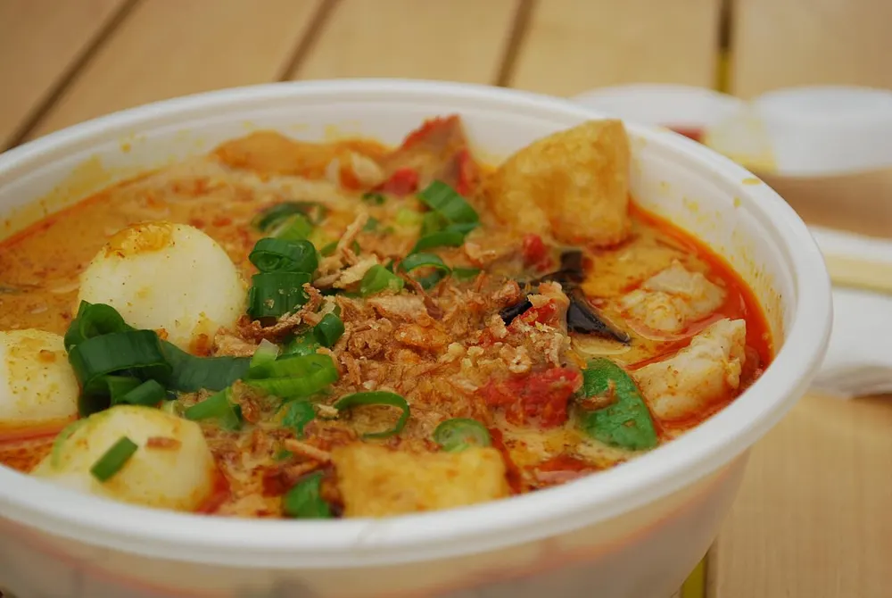 Curry laksa — noodles in a rich coconut curry soup with tofu puffs and fish balls