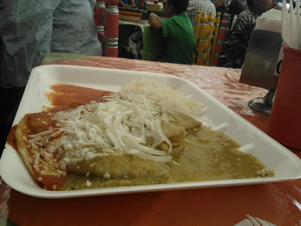 Enchiladas verdes — rolled tortillas in green salsa with cream, onion and cheese