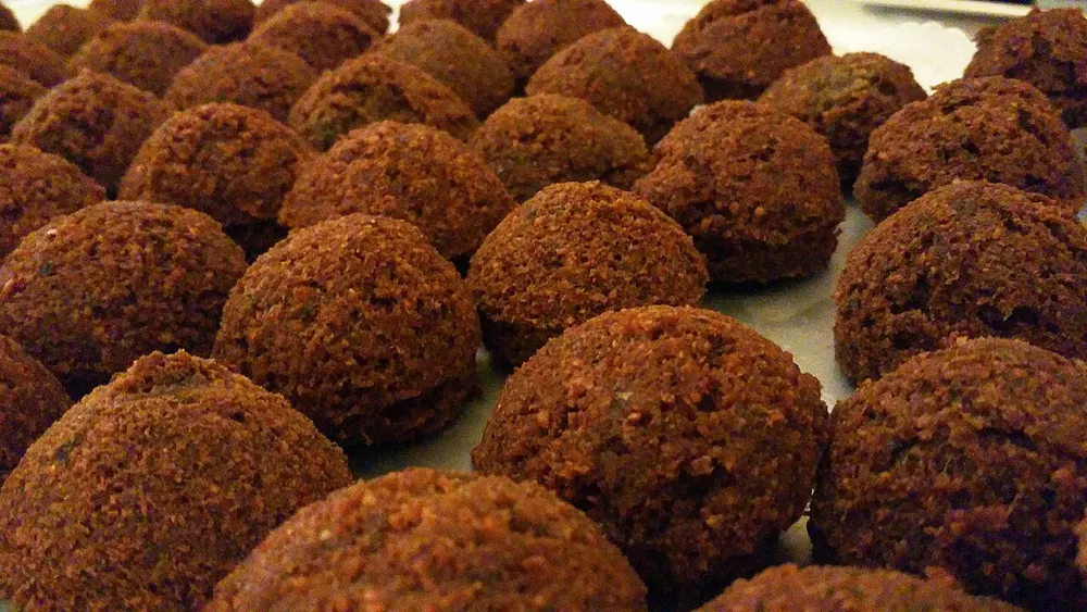 Rows of crisp deep-fried falafel balls with flecks of herb in the crust