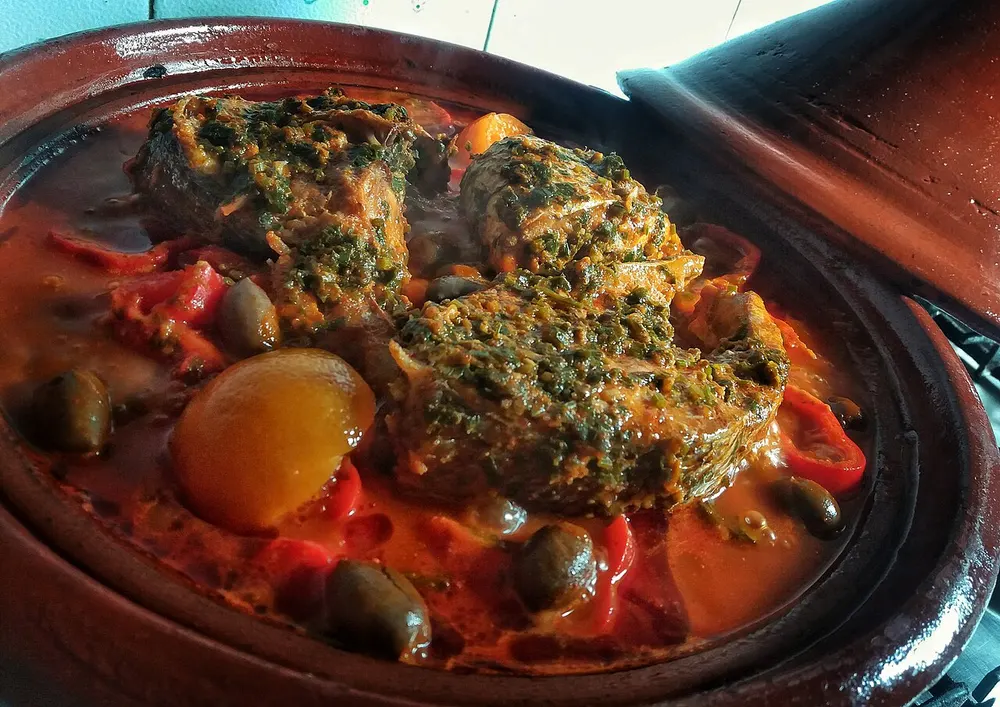 Fish tagine with chermoula — fish simmered in a herb-and-spice sauce with peppers and olives