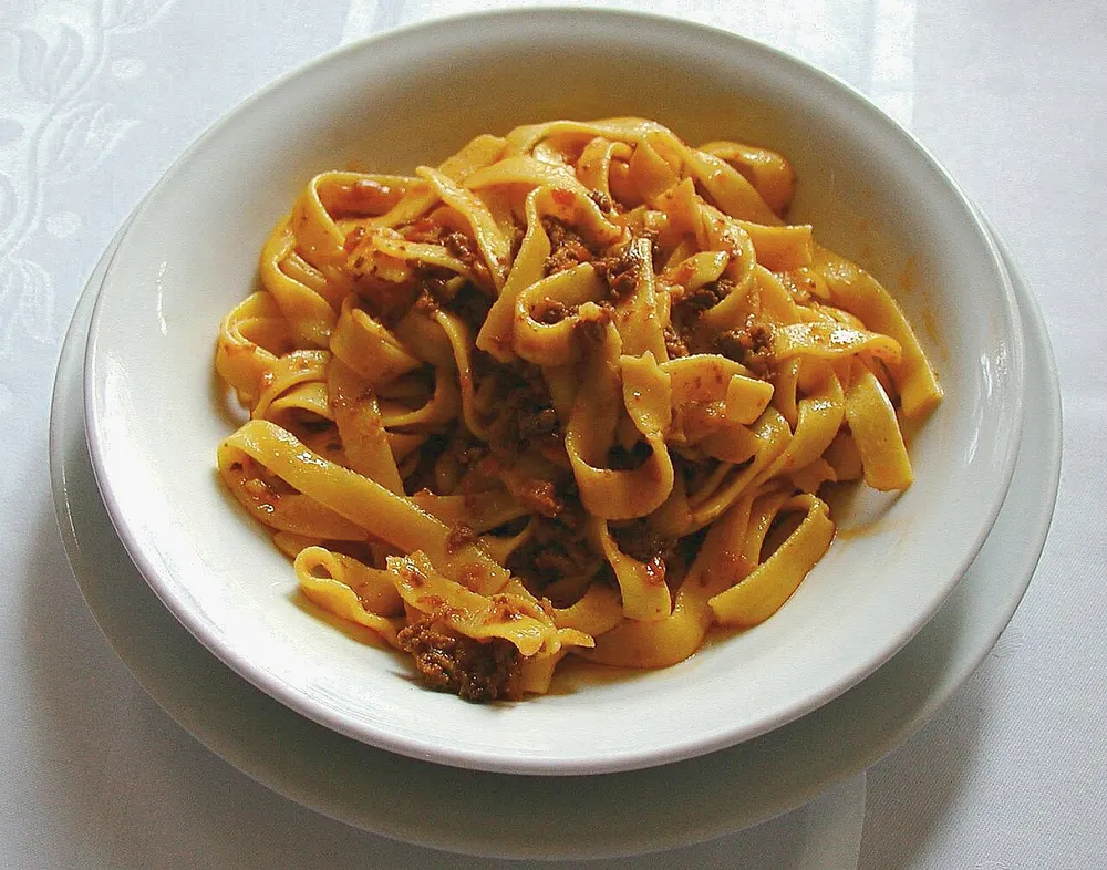 A bowl of fresh tagliatelle tossed in a meat ragù