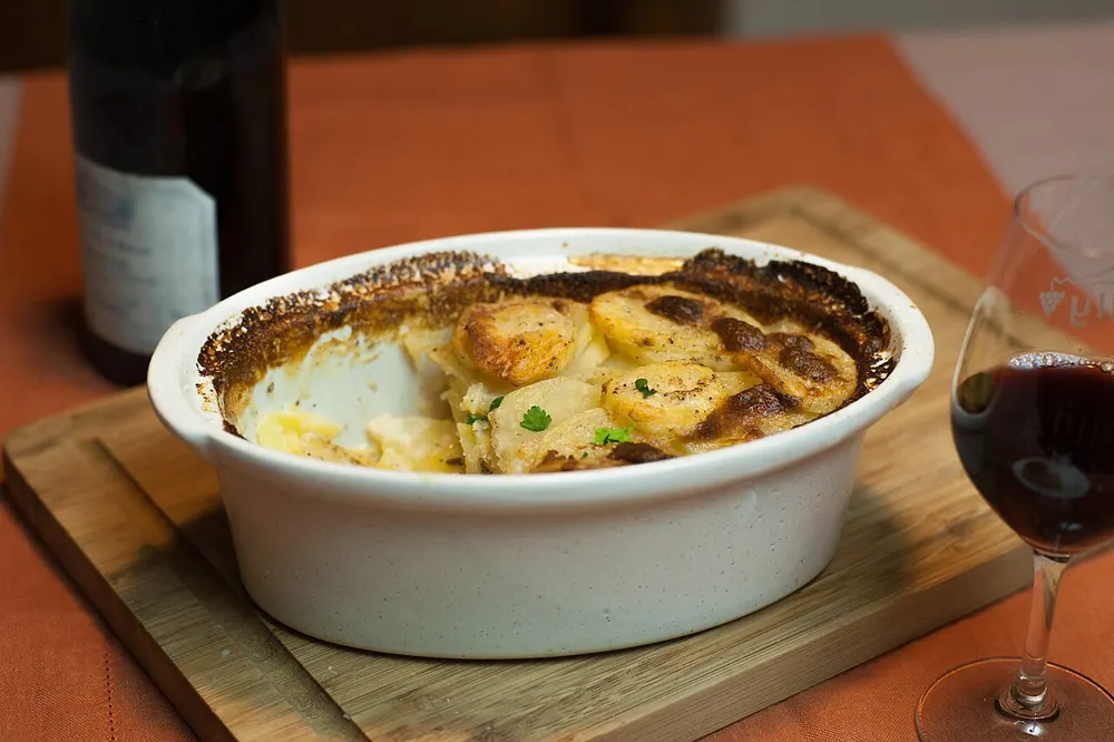 A dish of gratin dauphinois, the top browned and the potato layers just visible at the edge