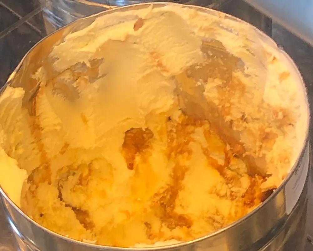 A tub of hokey pokey ice cream — pale vanilla streaked gold with pieces of honeycomb toffee through it