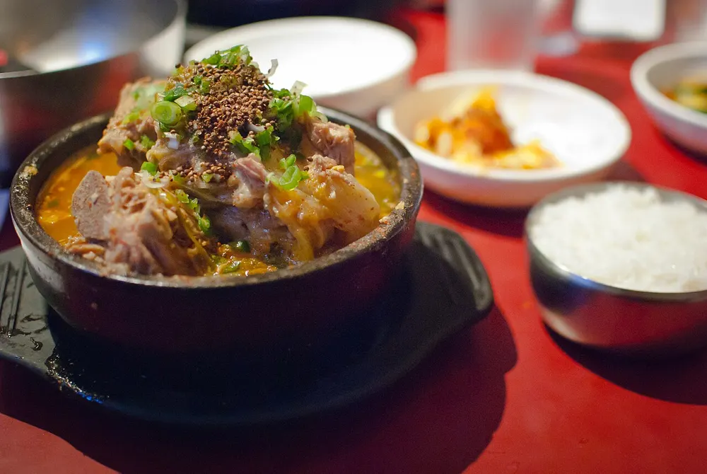 Gamjatang — pork-spine and potato stew with perilla seed and greens