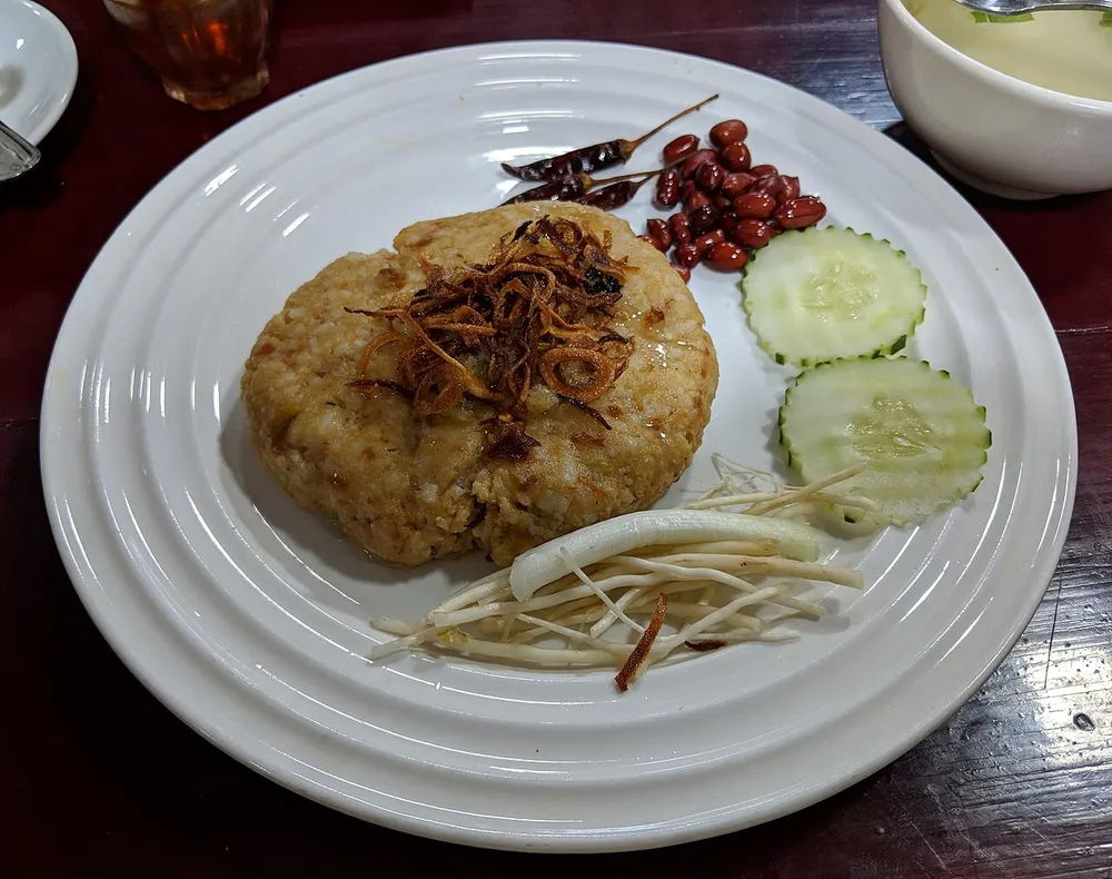 Htamin jin — Shan sour rice moulded with fish, topped with fried garlic and peanuts