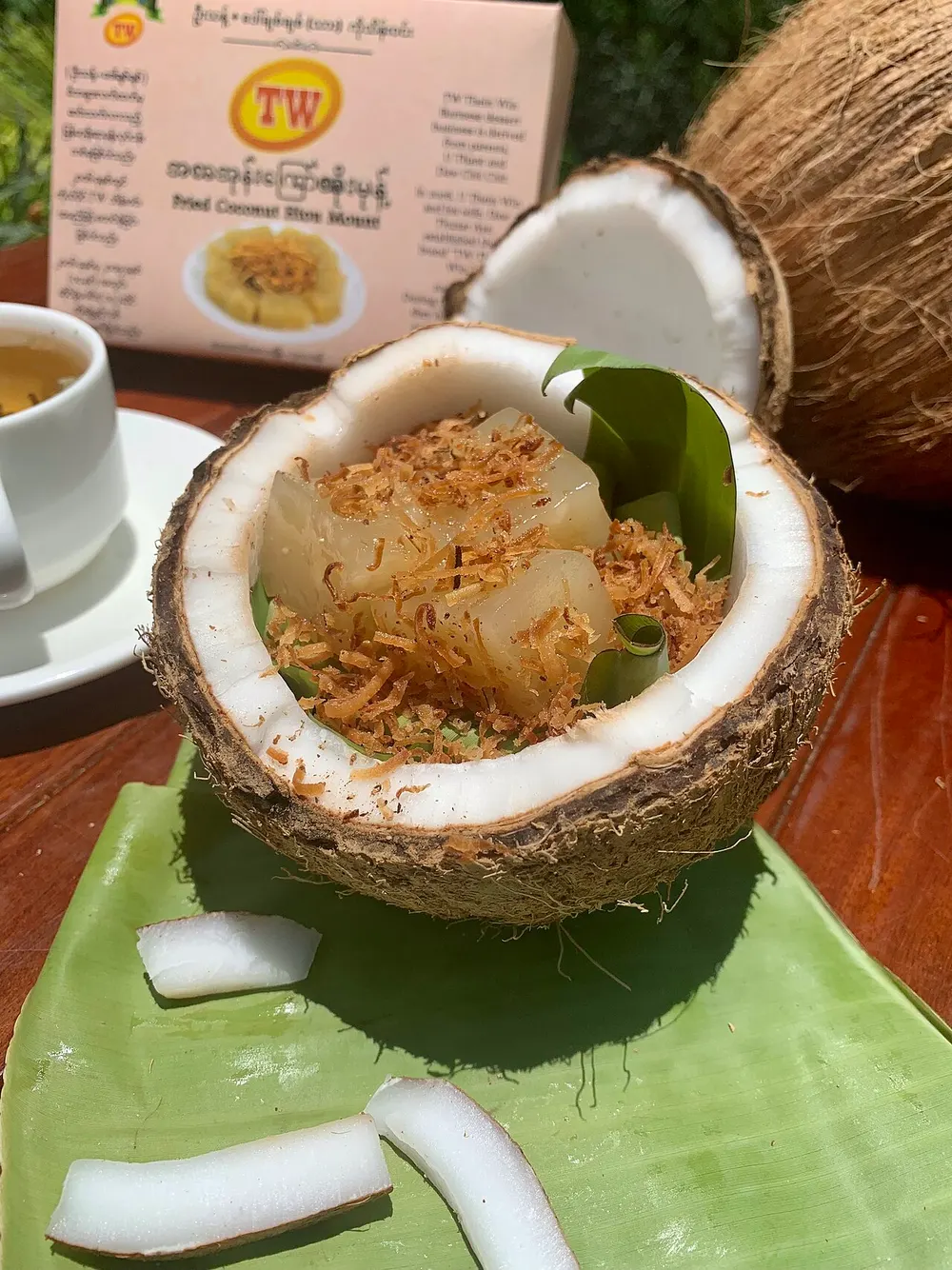 Htoe mont — Burmese glutinous rice cake with toasted coconut, served in a coconut shell