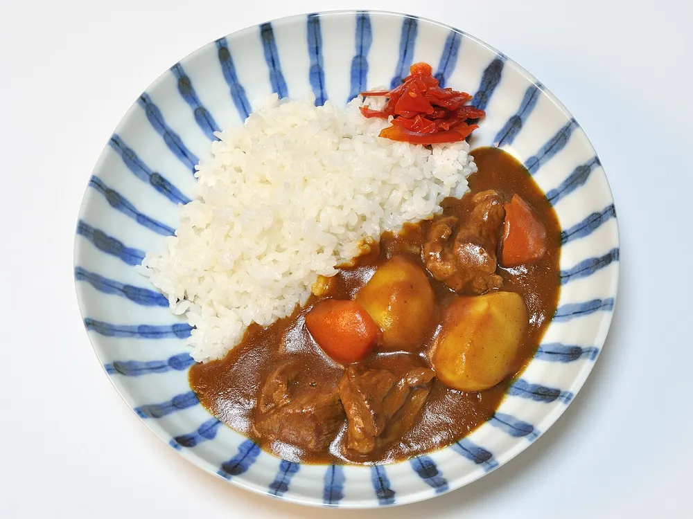 A plate of Japanese curry rice with beef and vegetables