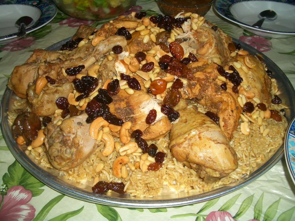 A platter of chicken kabsa, the rice scattered with cashews, pine nuts and raisins