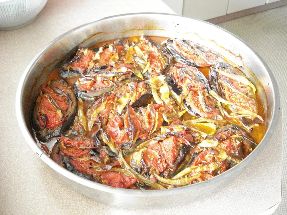 A tray of eggplants split and stuffed with spiced minced meat and tomato