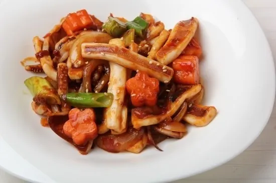 Spicy stir-fried squid with vegetables in red sauce
