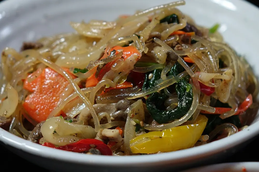 A plate of japchae — sweet potato glass noodles tossed with vegetables and strips of meat