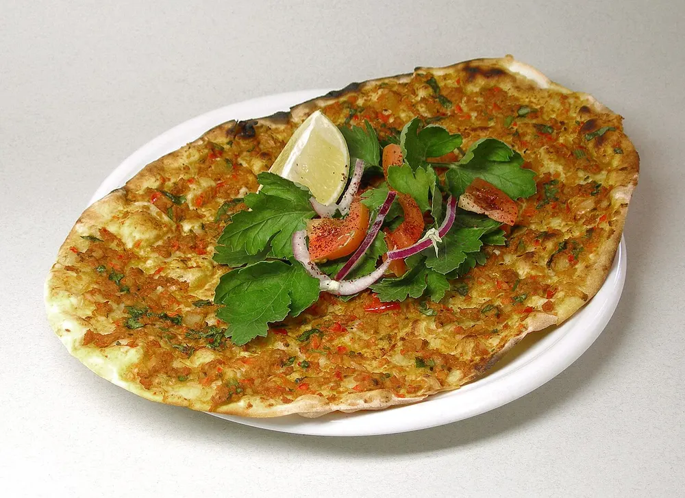 A thin lahmacun spread with spiced minced meat, herbs and lemon