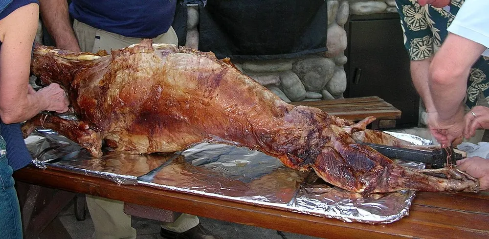 A whole spit-roasted lamb carved at the table