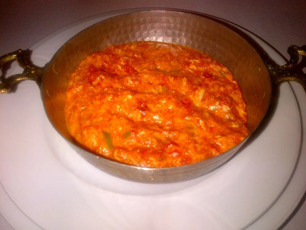 Menemen — eggs scrambled through simmered tomato and green pepper, served in a copper pan