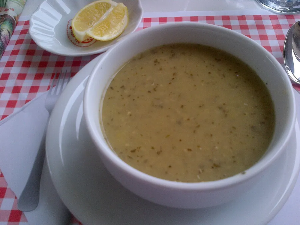 A bowl of smooth golden red-lentil soup with lemon