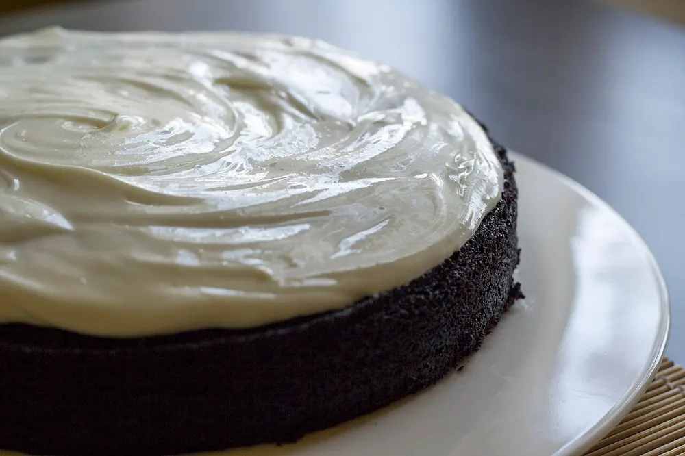 A dark chocolate Guinness cake topped with a swirled layer of pale cream cheese icing
