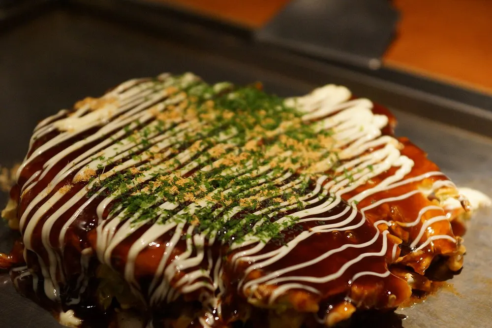 Okonomiyaki savory pancake with sauce, mayo and bonito flakes
