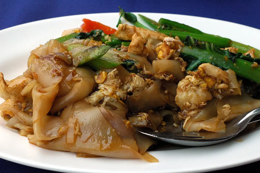 Pad see ew gai — wide rice noodles stir-fried in dark soy with chicken and greens
