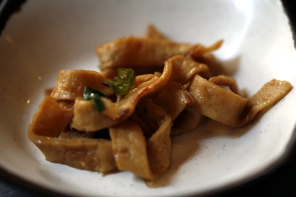 A bowl of eomuk-bokkeum — strips of fish cake stir-fried to a glossy soy glaze with green chili