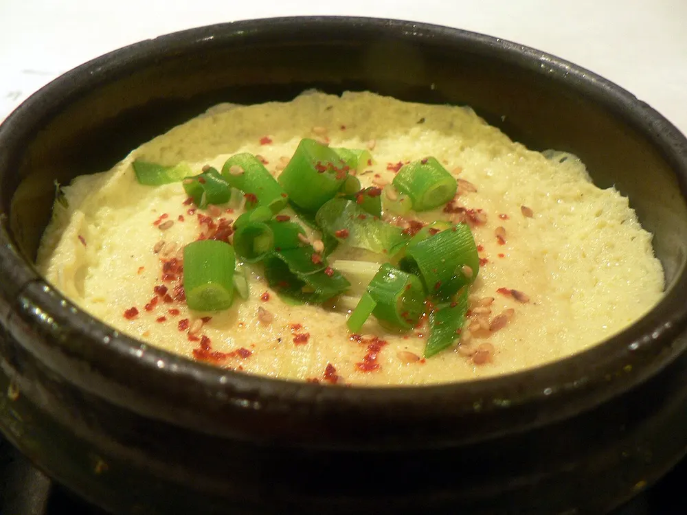 Gyeran-jjim, steamed egg risen in an earthenware ttukbaegi, topped with scallion