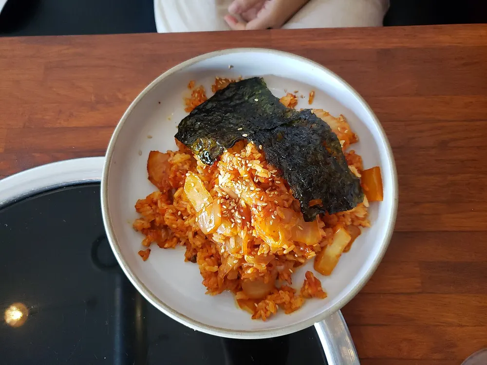 A plate of kimchi fried rice topped with a fried egg
