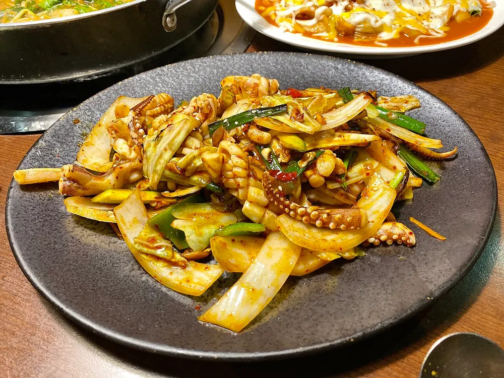 A plate of ojingeo-bokkeum: spicy stir-fried squid with cabbage, onion and scallion