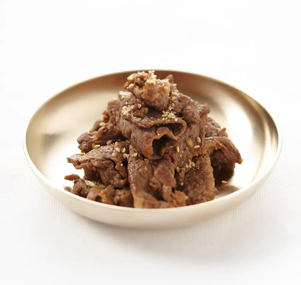 A pan of marinated bulgogi beef with onions and spring onion