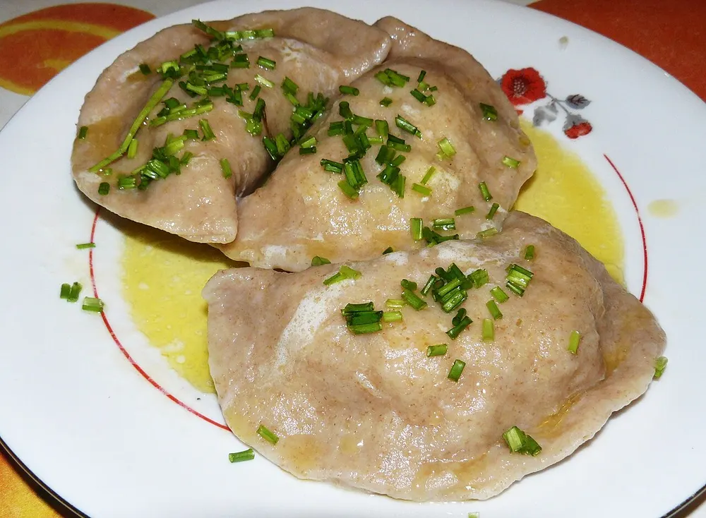 Pierogi ruskie — boiled dumplings filled with potato and cheese, with butter and chives