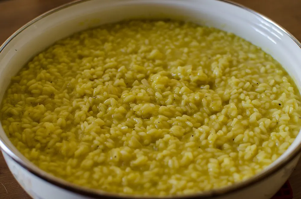 A dish of golden saffron risotto, creamy and glossy with the rice grains still distinct
