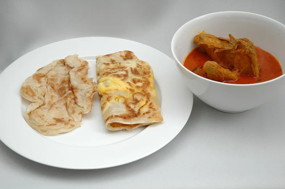 Roti prata — flaky griddled flatbread served with curry