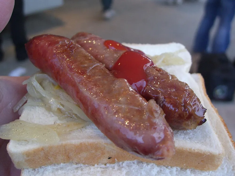 Sausage sizzle — a grilled sausage with onions and ketchup on white bread