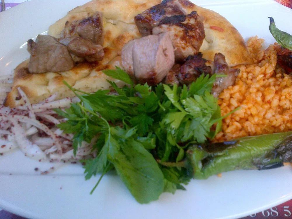 Grilled lamb cubes on flatbread with parsley and bulgur pilaf