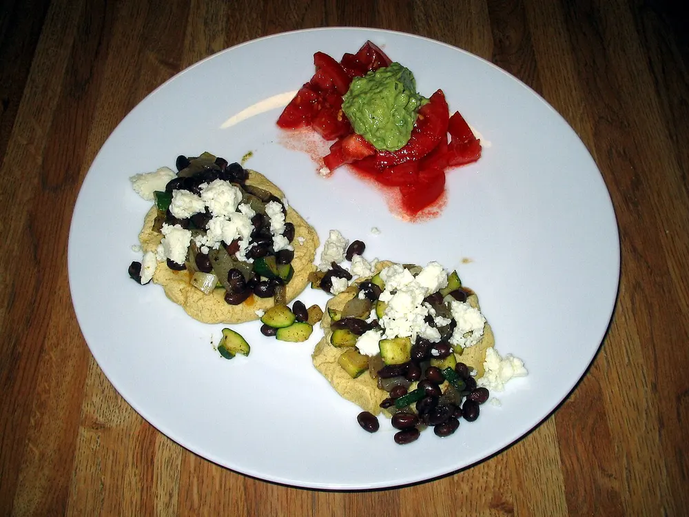 Sopes — thick corn bases topped with beans, cheese and avocado