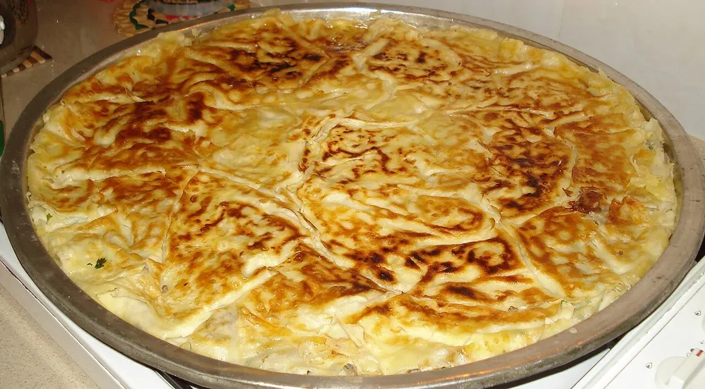 A large pan of layered buttery su böreği baked golden
