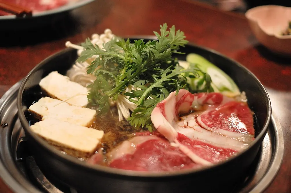 Sukiyaki beef and vegetables in an iron pot
